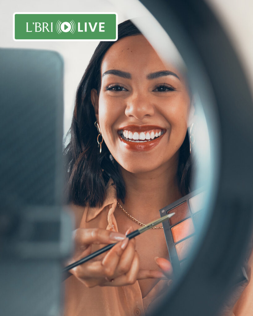 A woman putting makeup on online. 